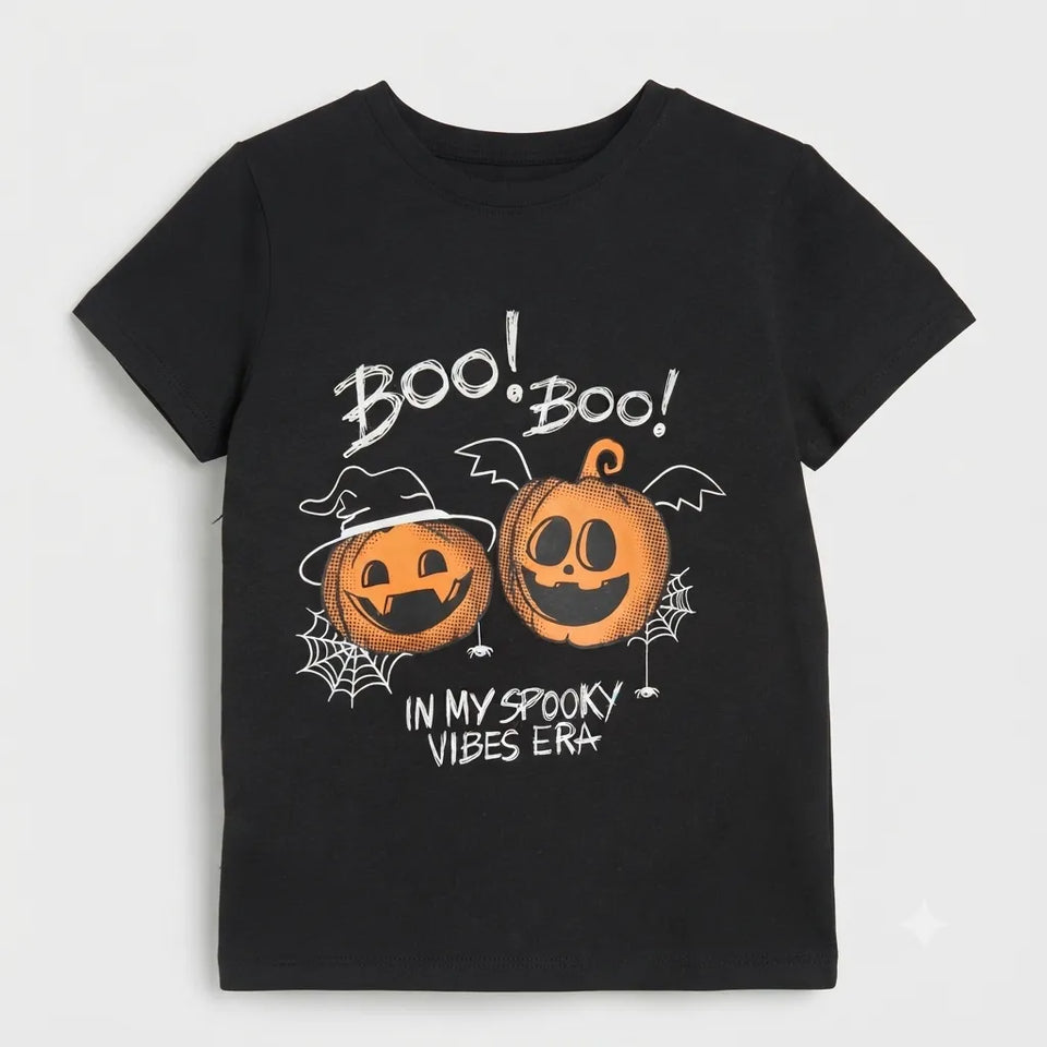 A black short-sleeve kids' t-shirt with a Halloween graphic print featuring two jack-o'-lanterns, spiderwebs, and the text 'BOO! BOO! IN MY SPOOKY VIBES ERA'.