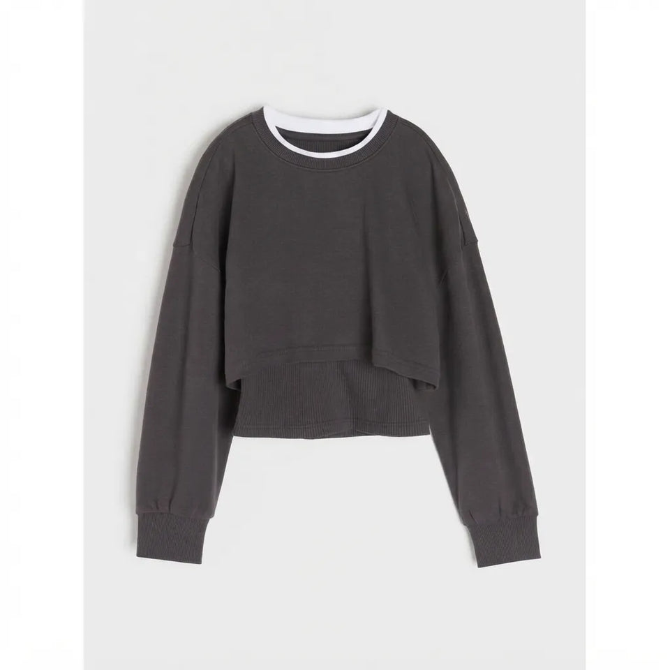 A dark gray cropped sweatshirt with a white ribbed crew neck collar, displayed flat against a light gray background.