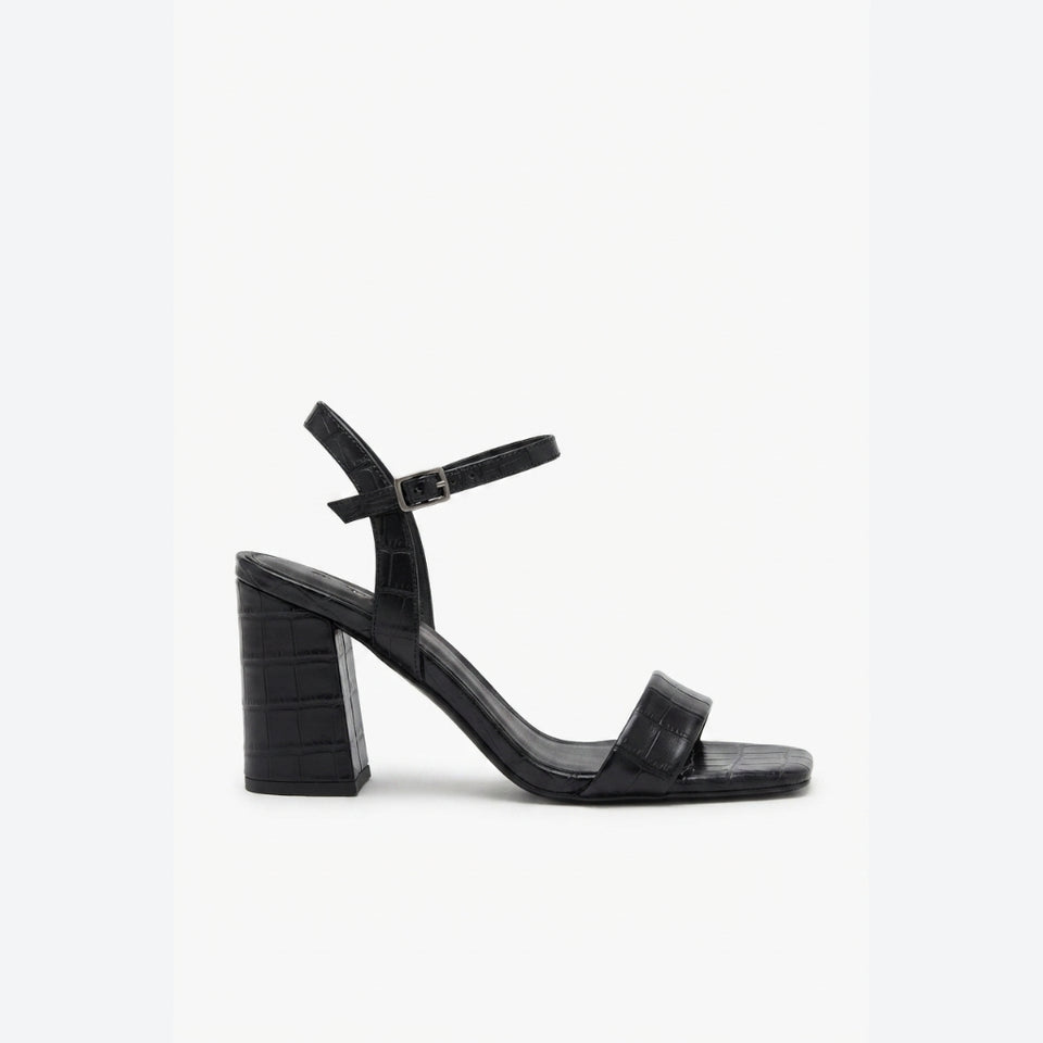 A single black block-heel sandal with a square toe, double front strap, and ankle buckle strap, shown in profile against a plain white background.