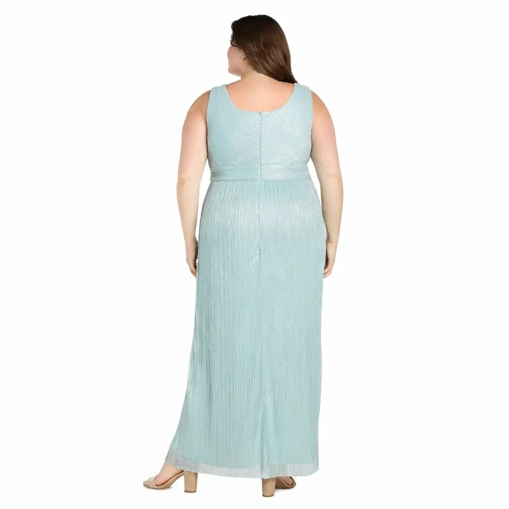A woman shown from the back wearing a sleeveless, floor-length light blue dress with a subtle textured pattern and vertical pleats, set against a plain white background.