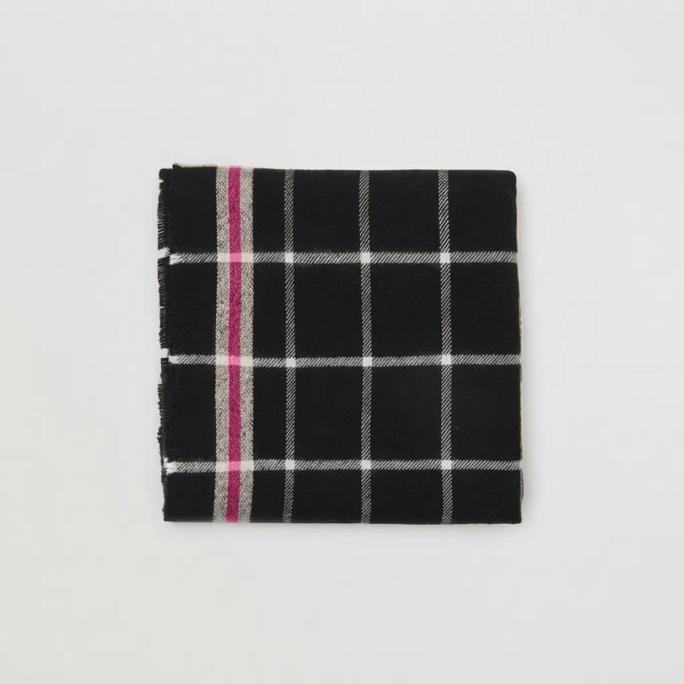 A folded black scarf with a white windowpane plaid pattern and a single vertical magenta stripe, displayed on a clean white background.
