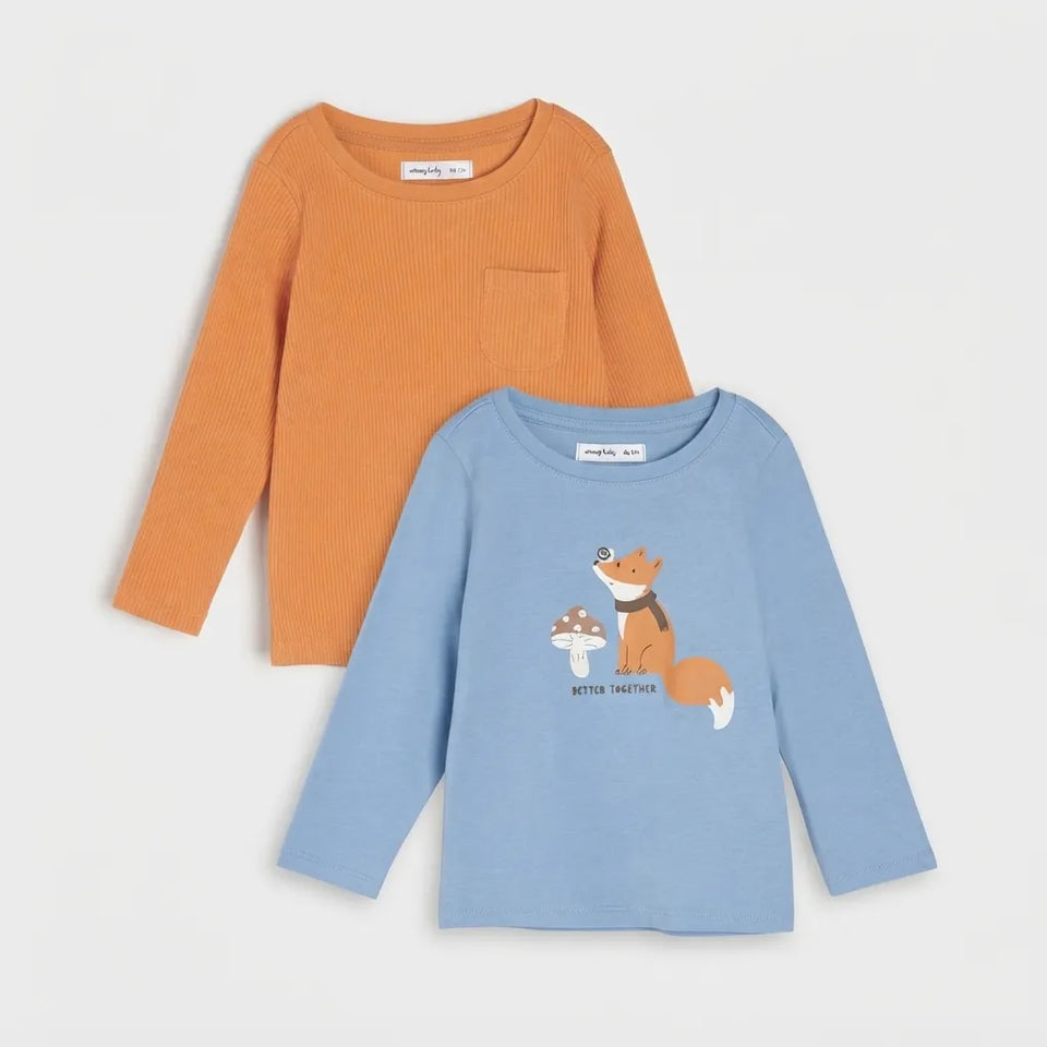 Two children's long-sleeve knit tops on a light gray background: an orange ribbed top with a chest pocket and a light blue top with a fox and mushroom graphic.