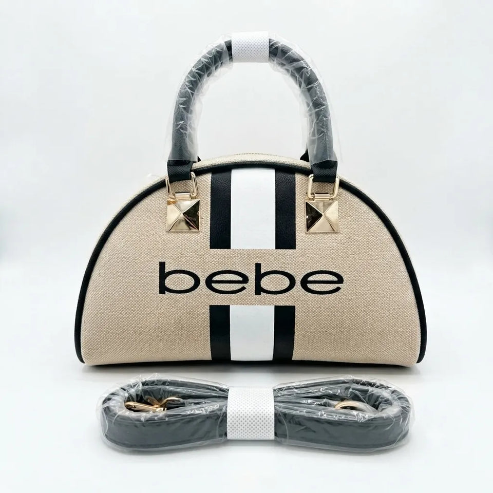 A beige dome-shaped handbag with black trim, two vertical white stripes, and the word 'bebe' printed in black across the front. The handles are wrapped in protective plastic, and a matching wrapped shoulder strap is placed in front on a light gray background.