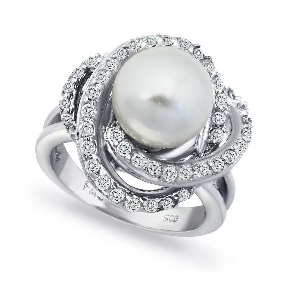 A silver ring featuring a large white pearl surrounded by multiple swirling bands of small clear stones, photographed on a clean white background.