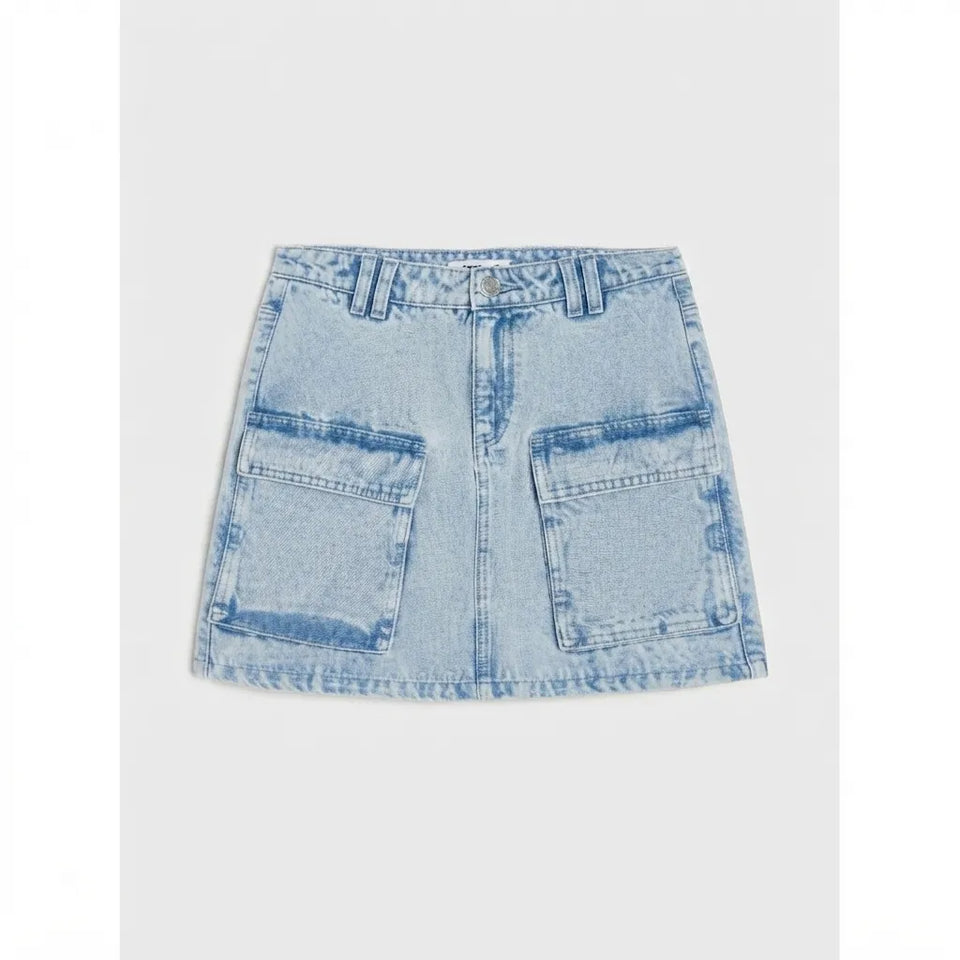 A light blue denim mini skirt with a button closure, belt loops, and two large front cargo-style pockets, shown flat against a light gray background.
