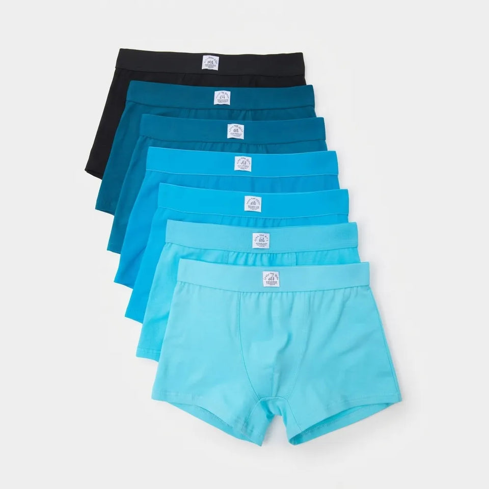 A 6-pack of boys' boxer briefs in various shades of blue, teal, and black, neatly stacked in a fan shape on a light gray background.