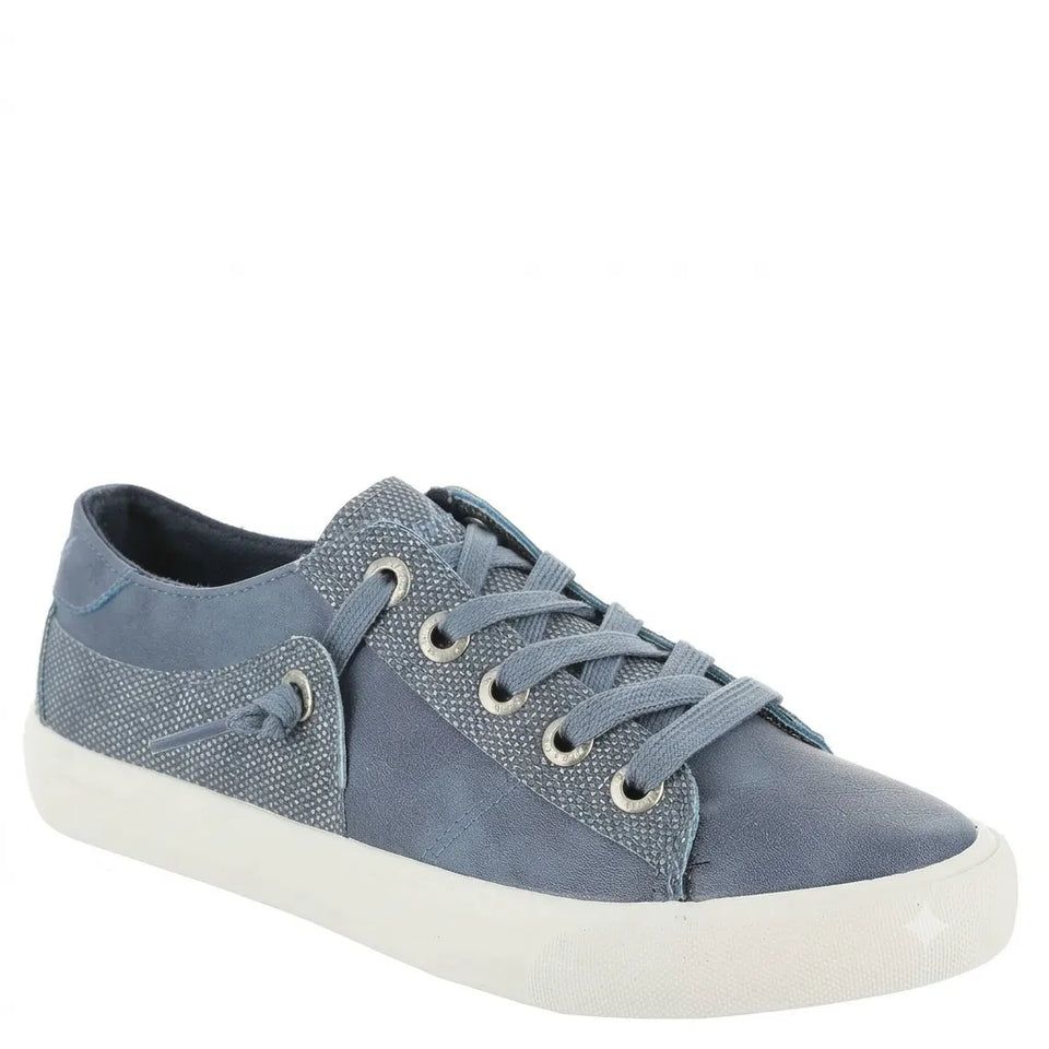 A low-top sneaker in a dusty blue-gray color, featuring a mix of textured canvas and smooth suede-like panels, matching blue-gray laces, and a thick white rubber sole.