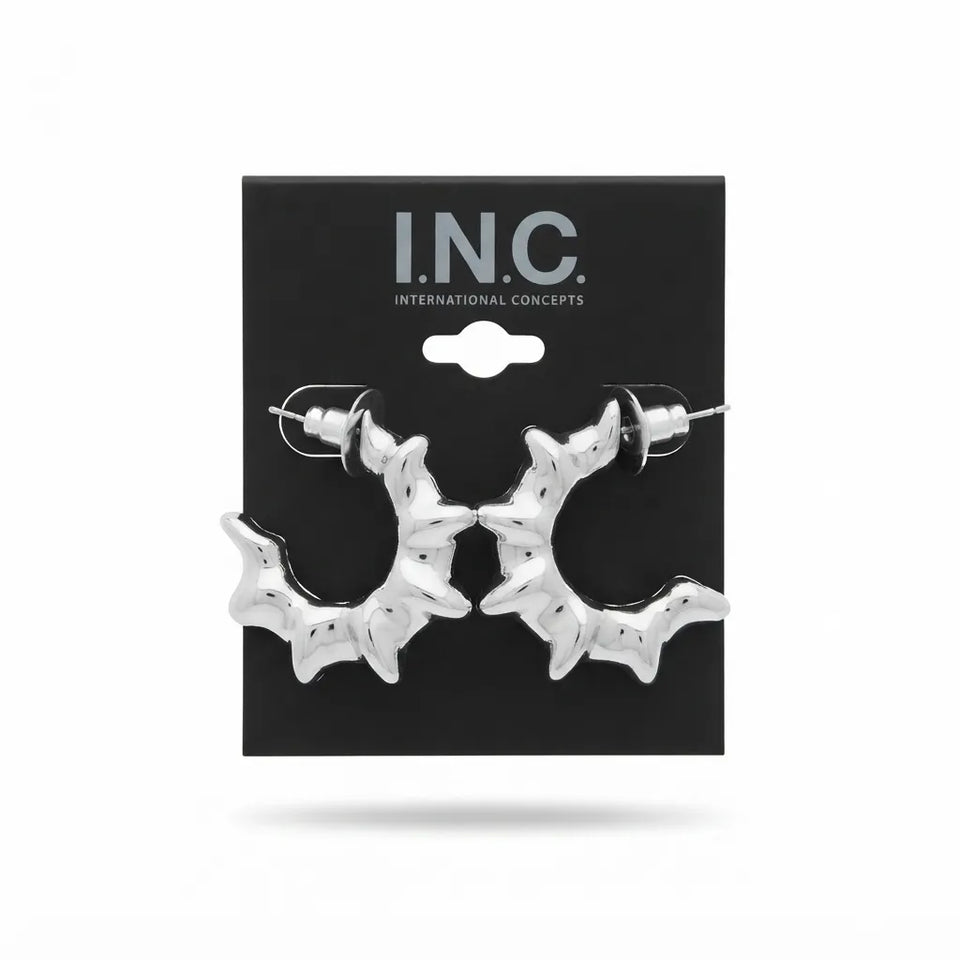 A pair of silver bat-shaped hoop earrings displayed on a black I.N.