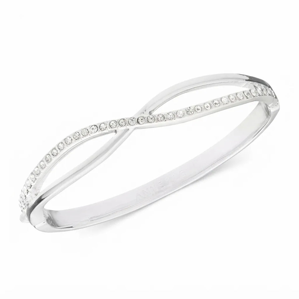 A silver infinity-style bangle ring featuring a row of small clear stones along one of the intersecting bands, set against a plain white background.