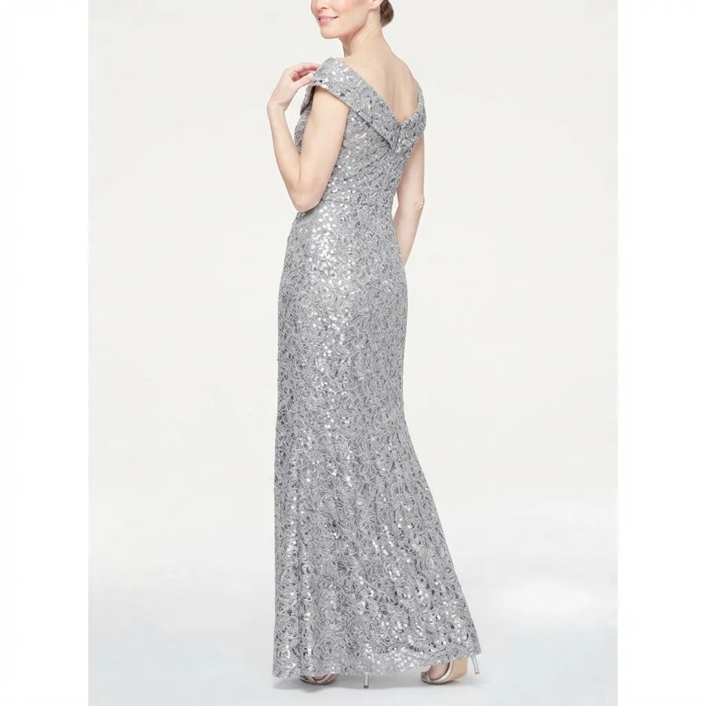A woman modeling a floor-length silver sequined gown with a deep V-neckline and off-the-shoulder straps, shown from the back against a plain light background.