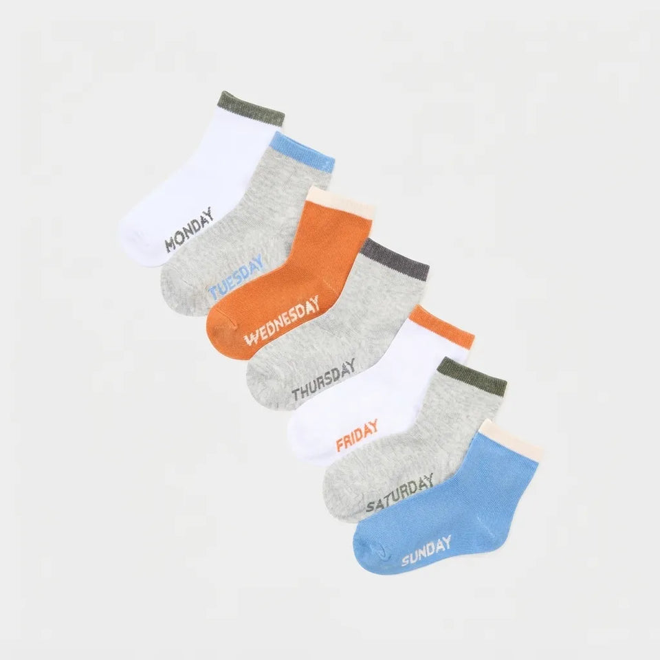 Six pairs of low-cut ankle socks arranged diagonally on a light gray background, labeled Monday through Sunday in black text.