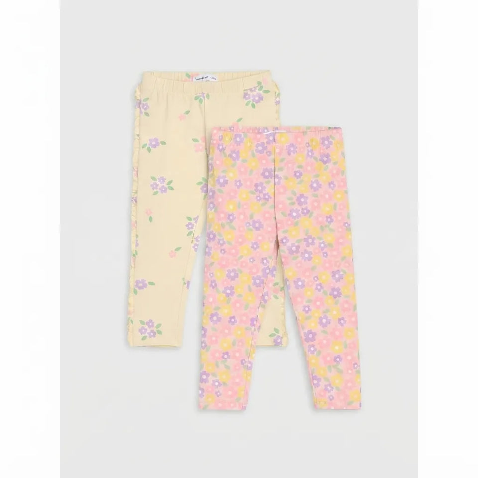 Two pairs of children's leggings laid flat on a light gray background. One pair is pale yellow with a small purple and green floral print, and the other is light pink with a dense multicolor floral print including pink, purple, yellow, and orange flowers.