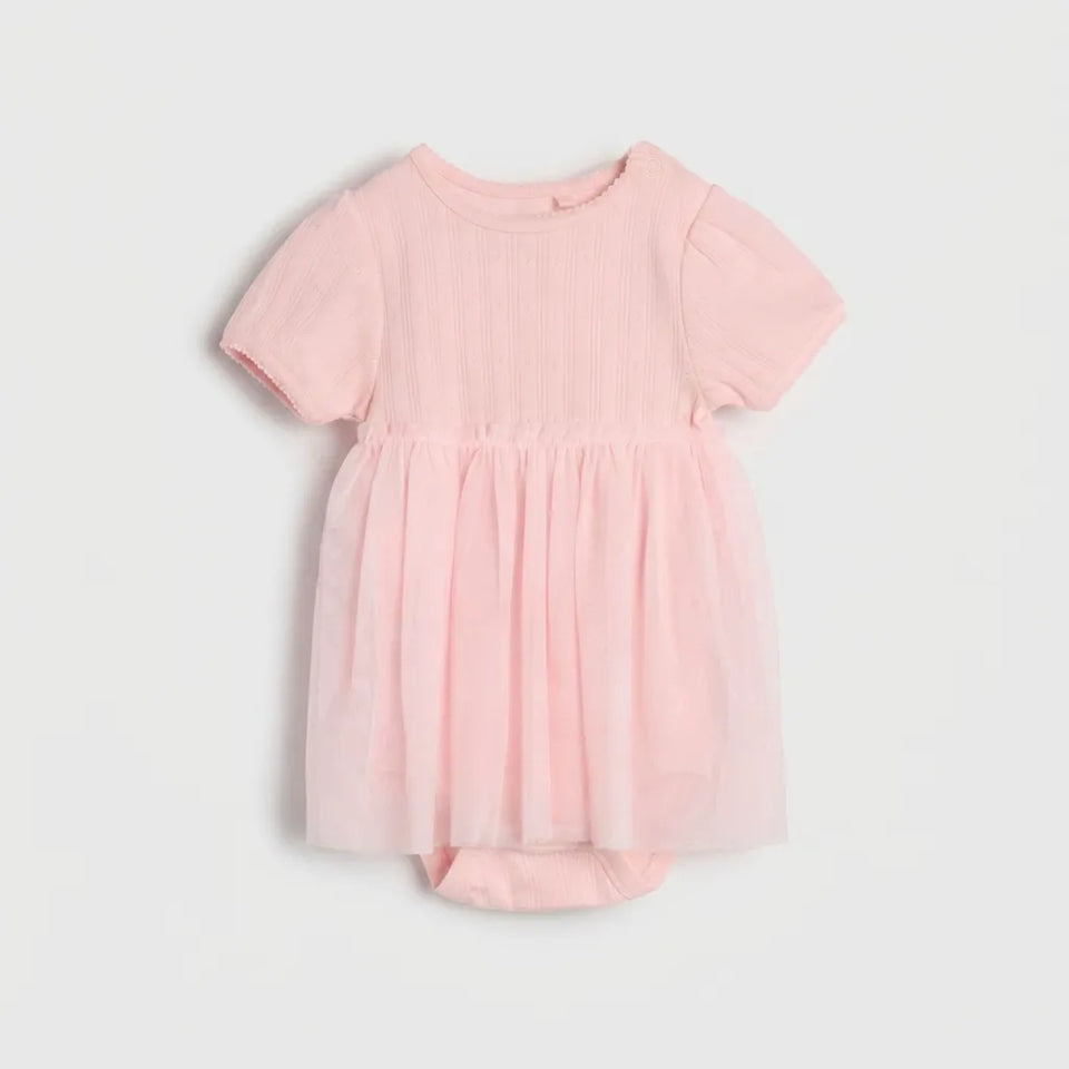 A baby girl's short-sleeve romper dress in light pink, featuring a ribbed bodice, smocked shoulders, and a gathered tulle skirt, shown flat on a light gray background.