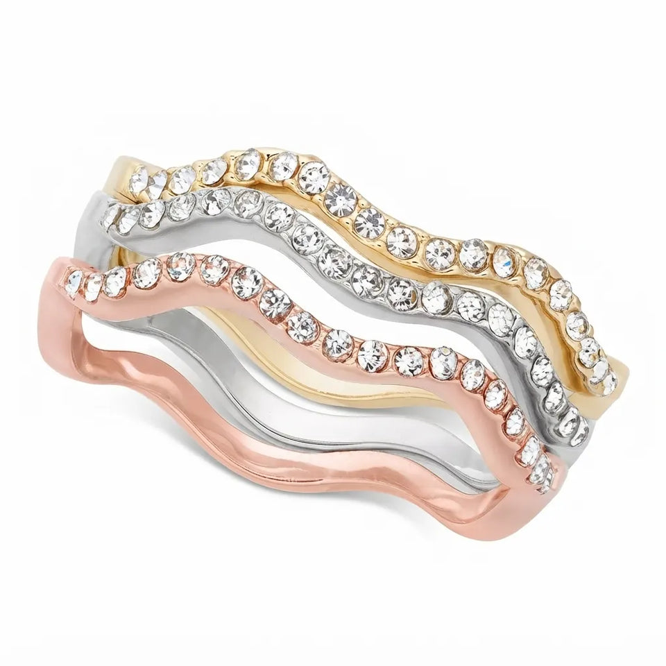 A wavy three-band stack ring featuring rose gold, yellow gold, and silver bands, each studded with clear cubic zirconia stones, shown on a white background.