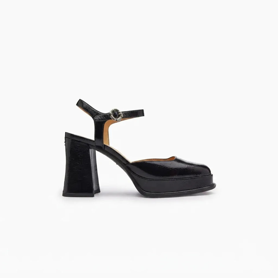 A single black patent leather platform sandal with a chunky block heel and ankle strap, shown in profile against a plain white background.