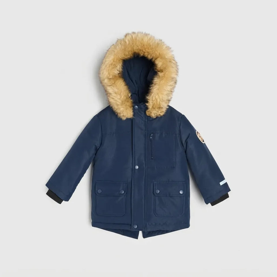 A navy blue children's parka jacket with a fluffy tan faux-fur trimmed hood, shown flat on a light gray background.