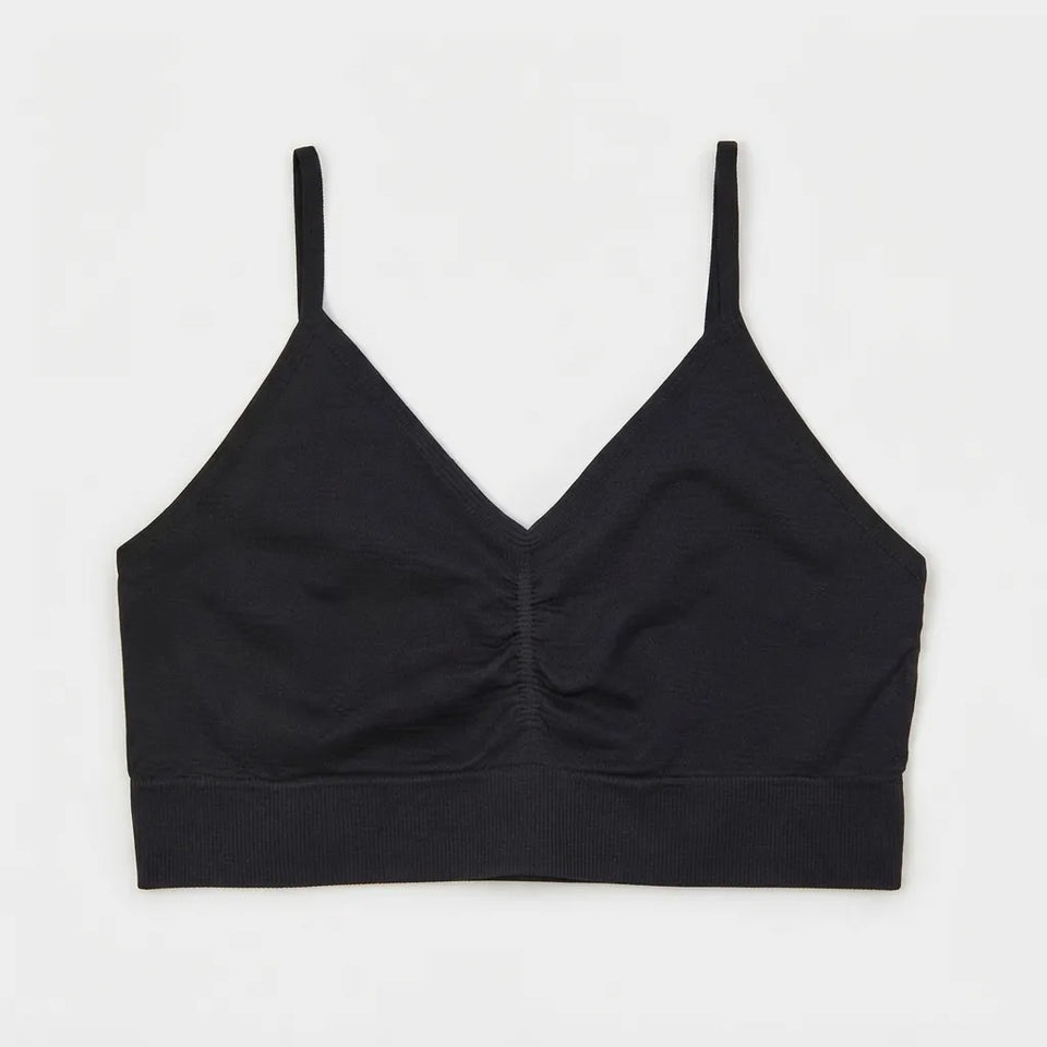 A black ribbed knit camisole crop top with thin shoulder straps and a gathered ruched center front, displayed flat against a light gray background.