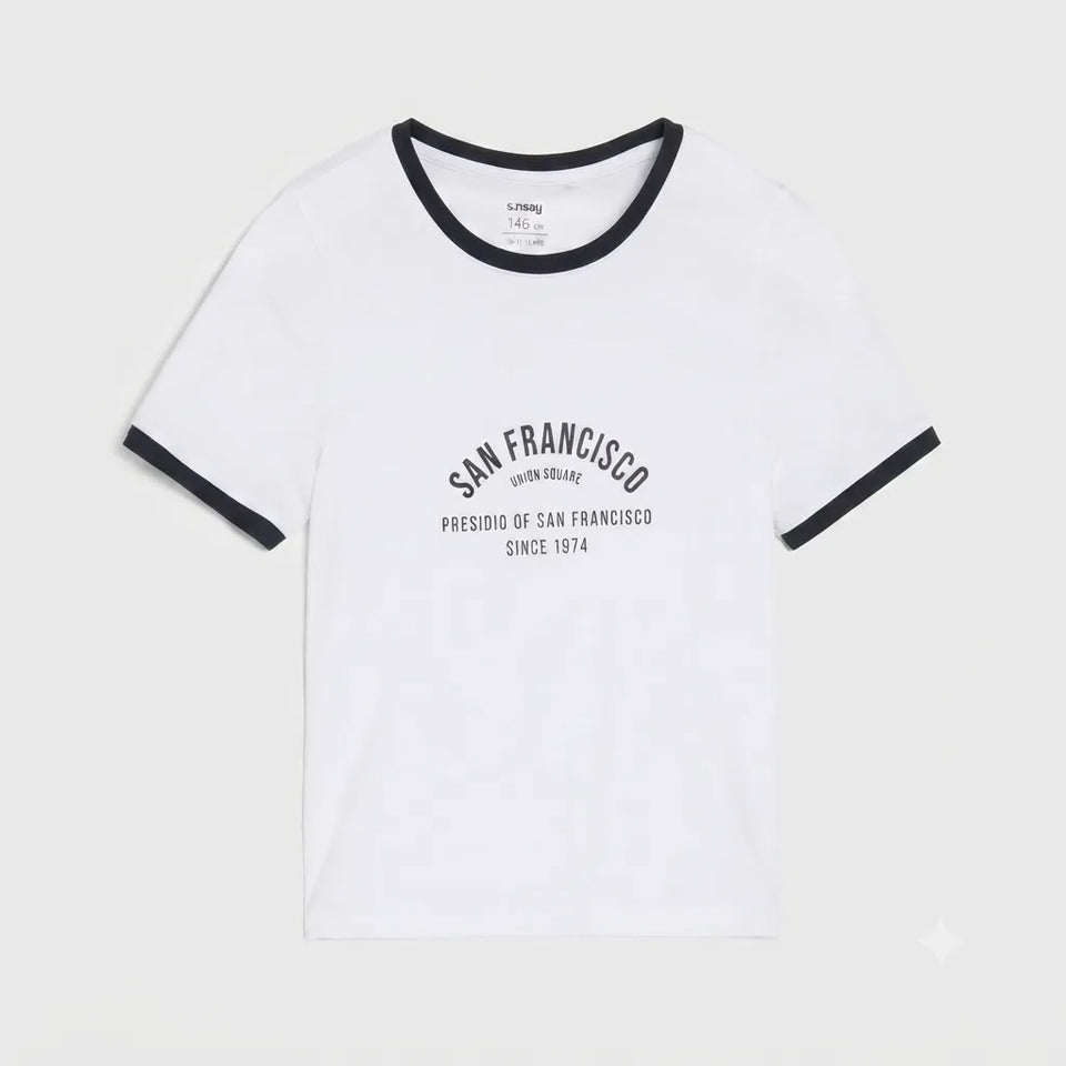 White ringer t-shirt with black trim on the crew neck and sleeve cuffs, featuring a black graphic print on the front that reads 'SAN FRANCISCO' and 'PRESIDIO OF SAN FRANCISCO SINCE 1974'.