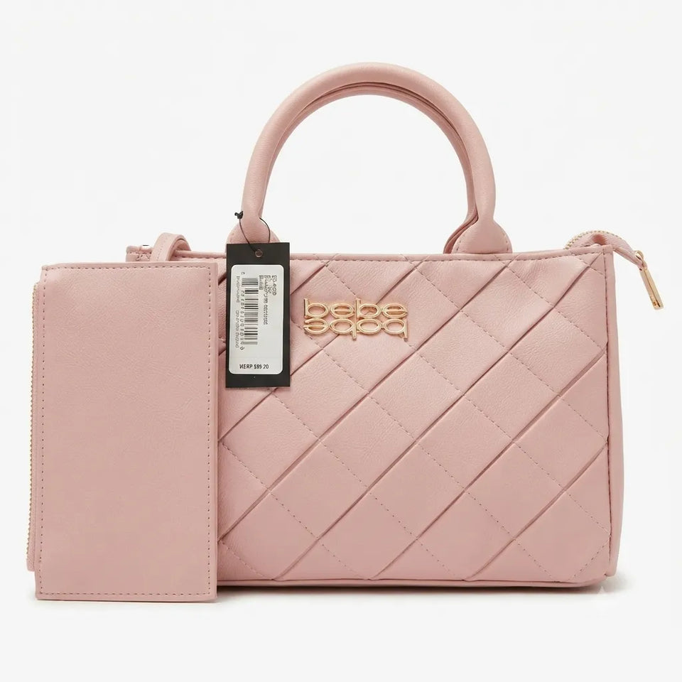 A light pink quilted handbag with a top handle, a matching zippered pouch, and a black hangtag, displayed on a clean white background.
