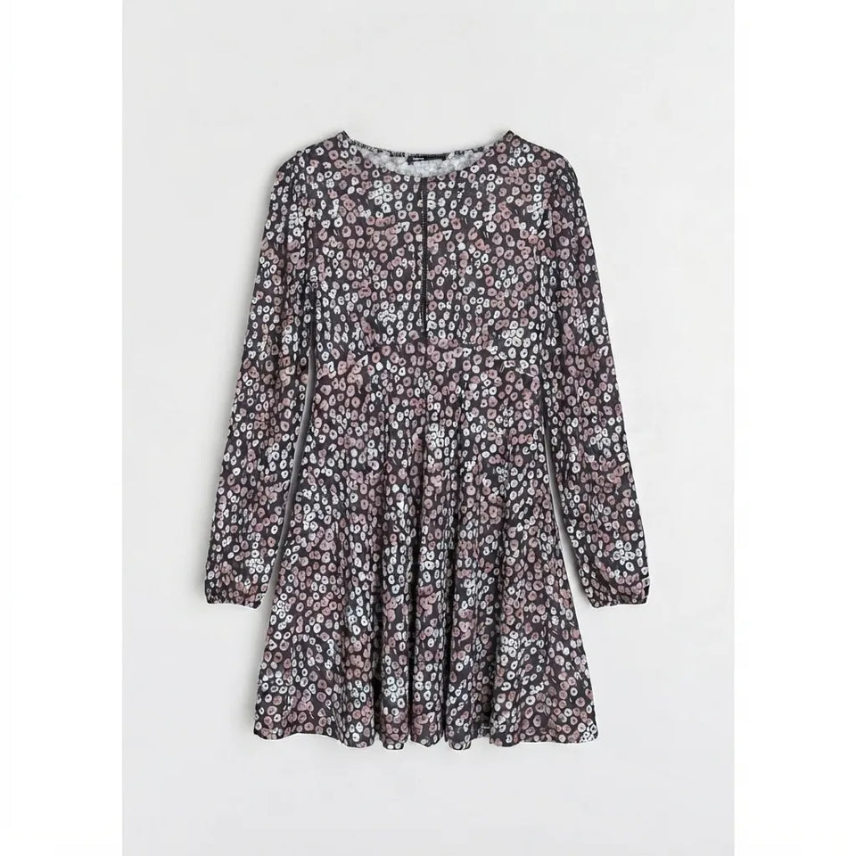 A long-sleeve, knee-length dress with a dense small floral print in dusty pink, white, and black, displayed flat against a light gray background.