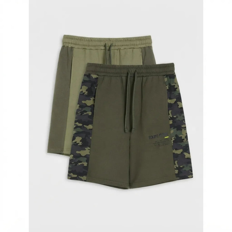 Two pairs of men's athletic shorts in olive green, with one pair featuring solid olive green panels and the other featuring dark green and black camouflage panels on the sides. Both pairs have elastic waistbands with drawstrings.