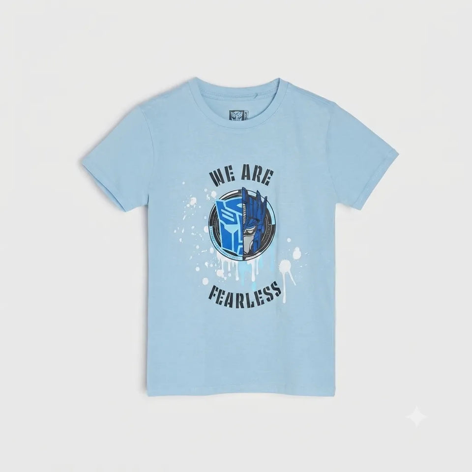 A light blue short-sleeve kids' t-shirt with a graphic on the front featuring the Transformers logo and the text 'WE ARE FEARLESS' in black, displayed on a light gray background.