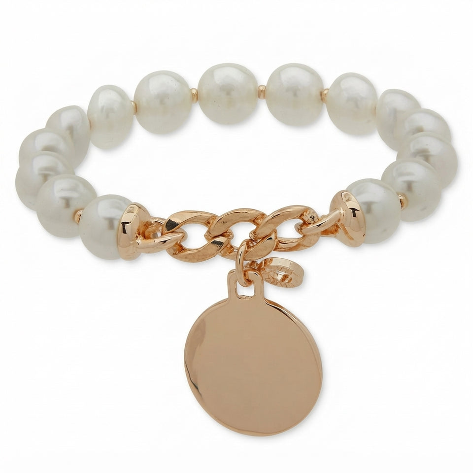 A stretch bracelet featuring lustrous white pearl-like beads, a polished rose gold chain clasp, and a round rose gold disc charm, shown on a clean white background.