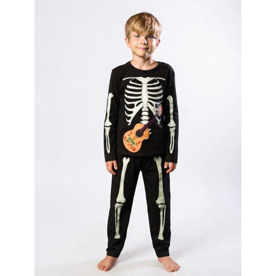 A young boy modeling a black long-sleeve pajama set with a white skeleton print and a guitar graphic on the front, standing against a light gray studio background.