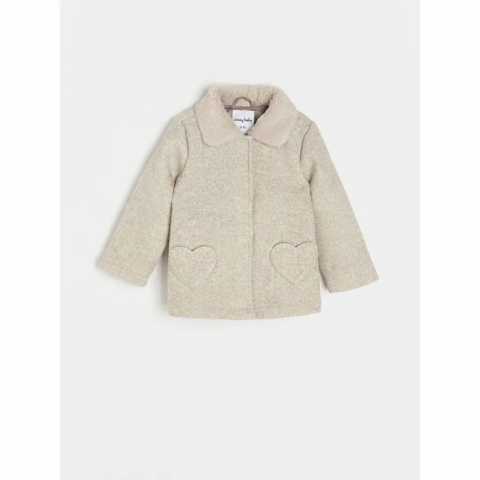 A beige tweed jacket for toddlers, featuring a soft cream collar, long sleeves, and two heart-shaped patch pockets on the front, displayed against a light gray background.