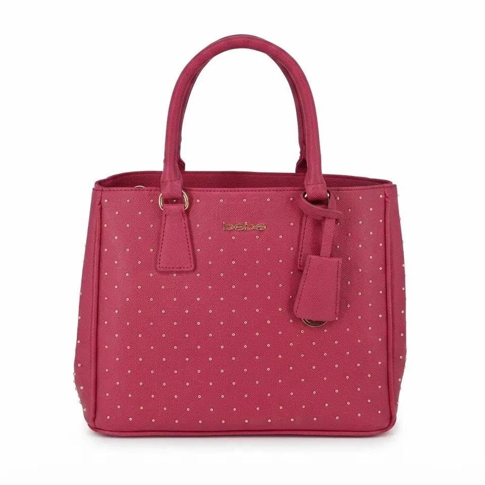 A pink faux-leather handbag with a polka-dot pattern, featuring dual top handles, a hanging leather tag, and gold-tone hardware, shown against a plain white background.