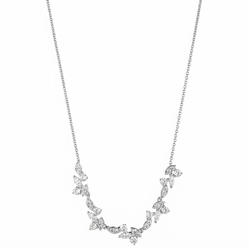 A silver-toned necklace featuring a delicate chain and a curved, leafy vine pendant adorned with small clear stones, shown against a plain white background.