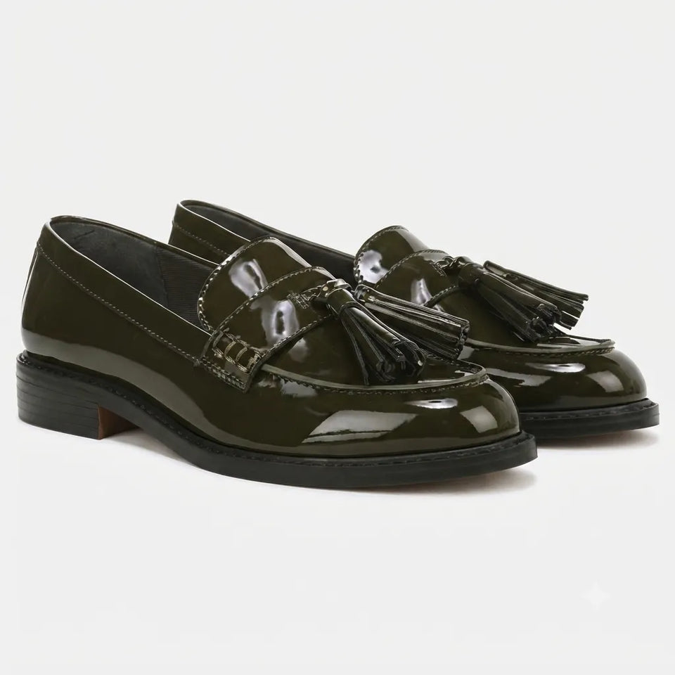 A pair of glossy dark olive green patent leather tassel loafers with black soles, displayed on a clean white background.