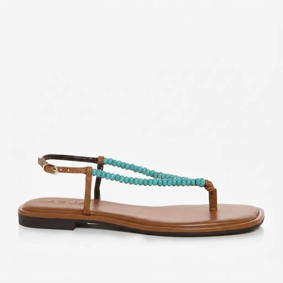 A single flat thong sandal with a tan leather footbed and sole, featuring a beaded turquoise blue strap and a matching ankle strap with a small gold buckle, shown against a plain white background.