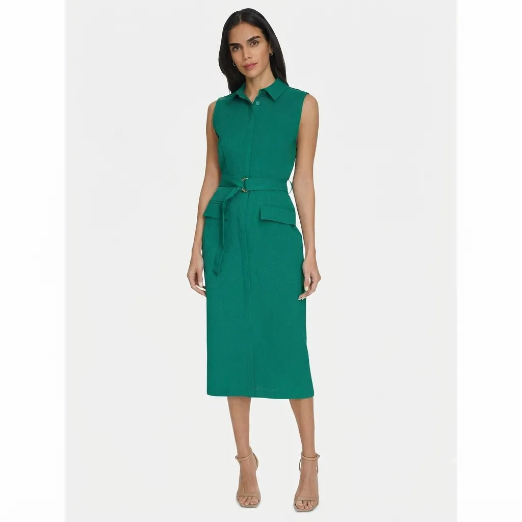 A woman modeling a sleeveless emerald green midi dress with a collar, front button placket, matching waist tie belt, and flap pockets, paired with beige high-heeled sandals against a light gray studio background.