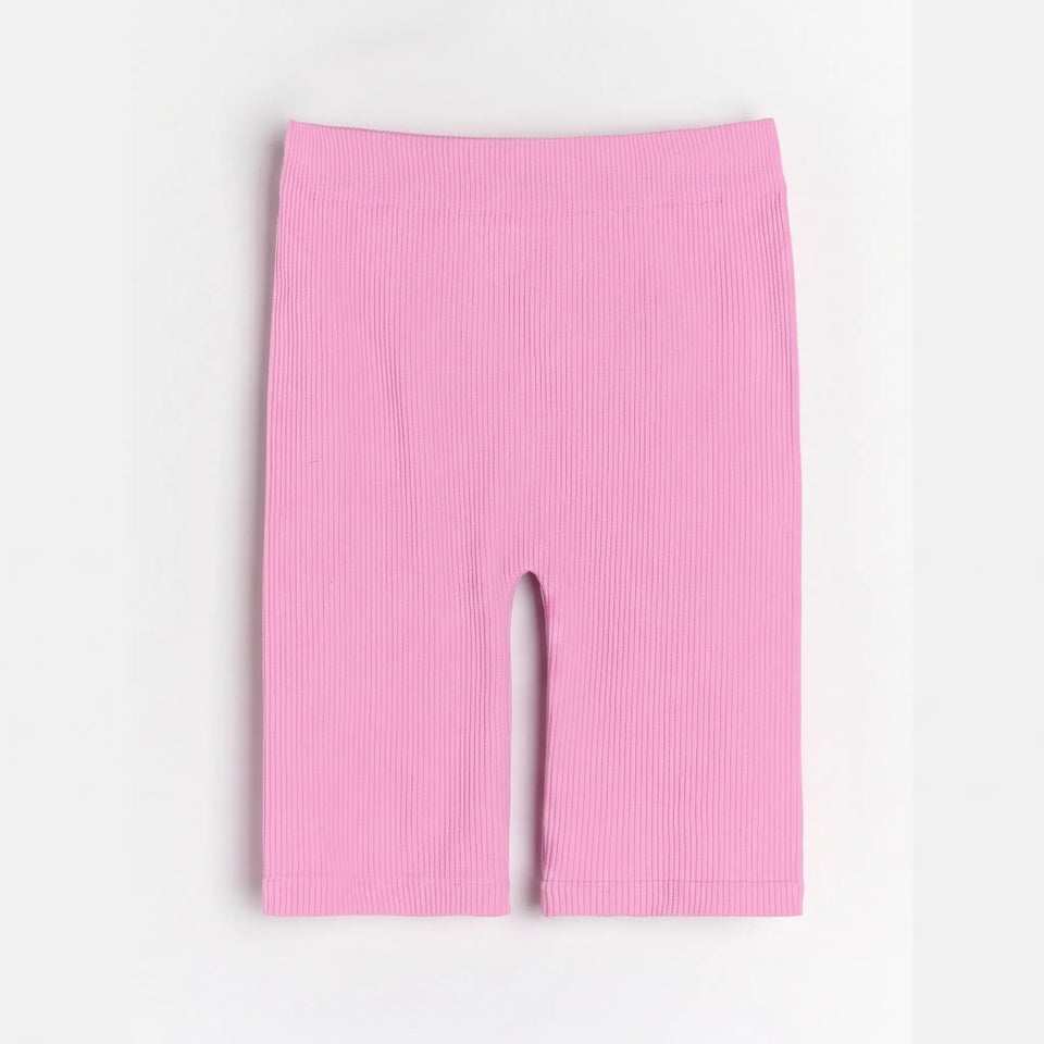 Pink ribbed biker shorts with a wide waistband, laid flat on a light gray background.