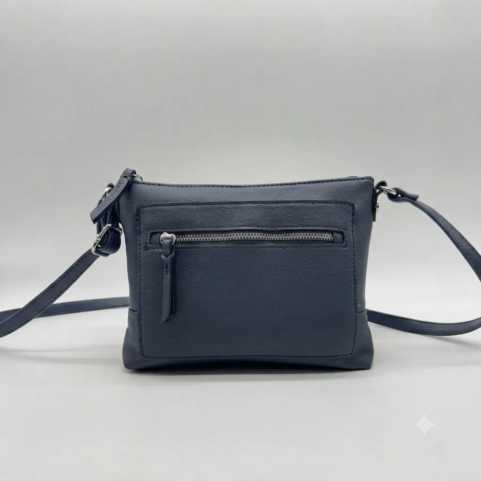 A dark blue leather crossbody bag with a front zippered pocket and a matching shoulder strap, photographed against a neutral gray background.