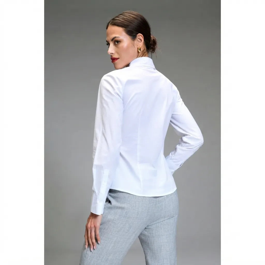 A woman wearing a white long-sleeve collared blouse and light gray trousers, photographed from the back against a plain gray studio background.