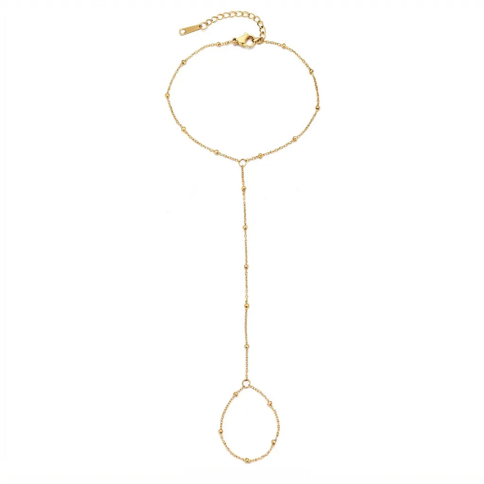 A delicate gold lariat-style chain necklace with a top ring, a long drop chain, and a dangling circular link, shown on a plain white background.