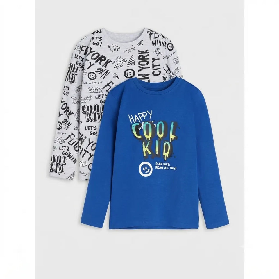 Two long-sleeve kids' shirts displayed together on a light gray background. The front shirt is royal blue with 'HAPPY COOL KID' text and a smiley face graphic.