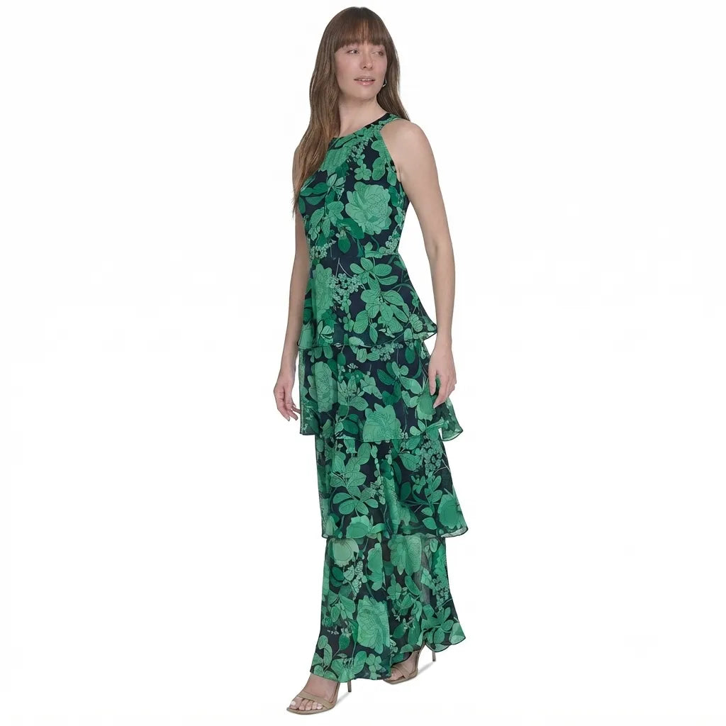 A woman modeling a sleeveless, one-shoulder green floral maxi dress with a tiered ruffle skirt, set against a plain white background.