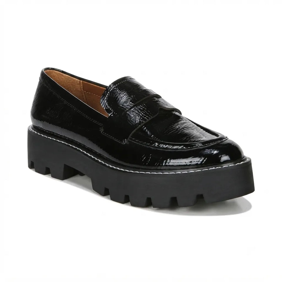 A black patent leather penny loafer with a chunky lug sole, shown from a three-quarters angle on a white background.