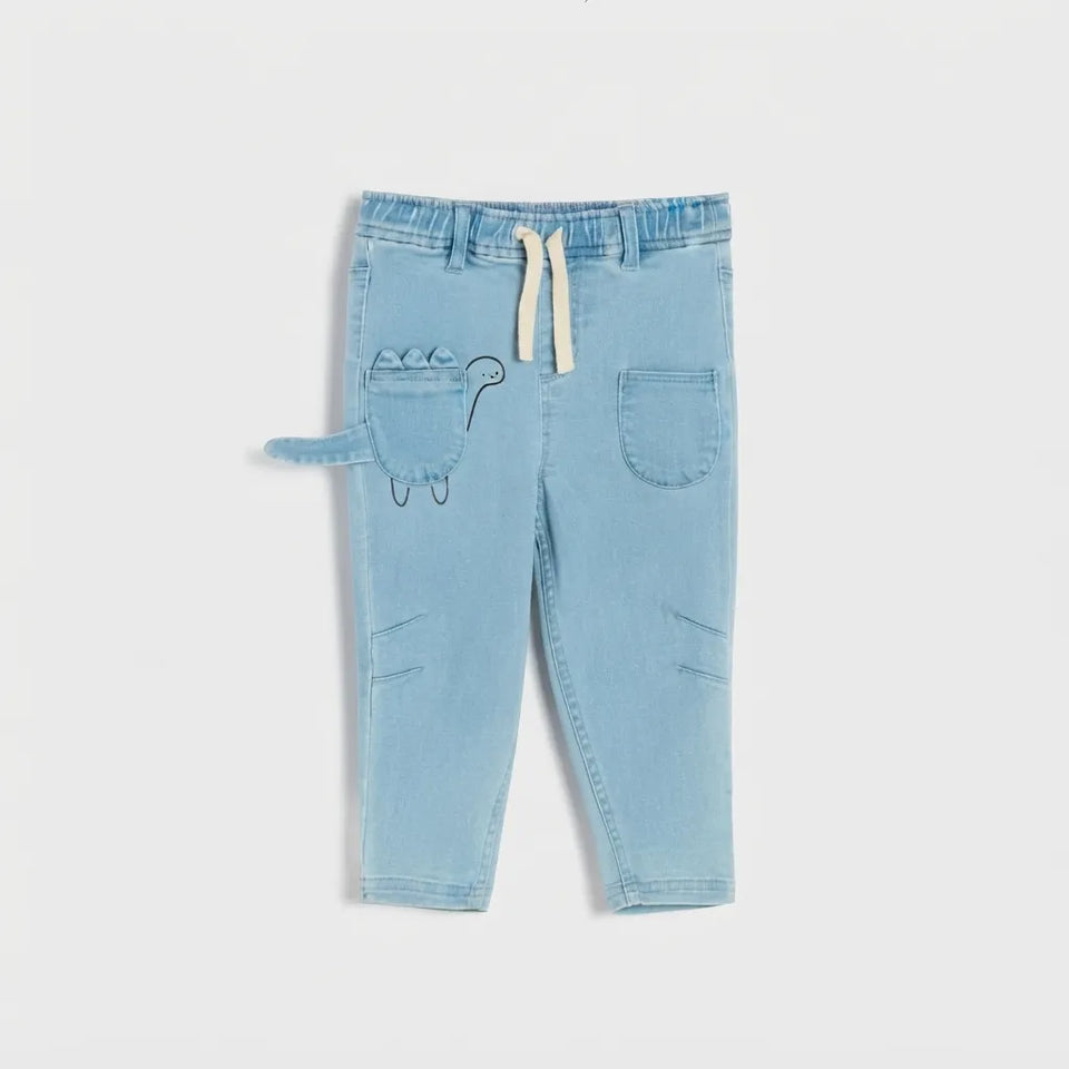 Light blue denim pants for toddlers, featuring a drawstring waist, side cargo pockets, and a dinosaur tail detail on the front pocket, shown against a plain light gray background.