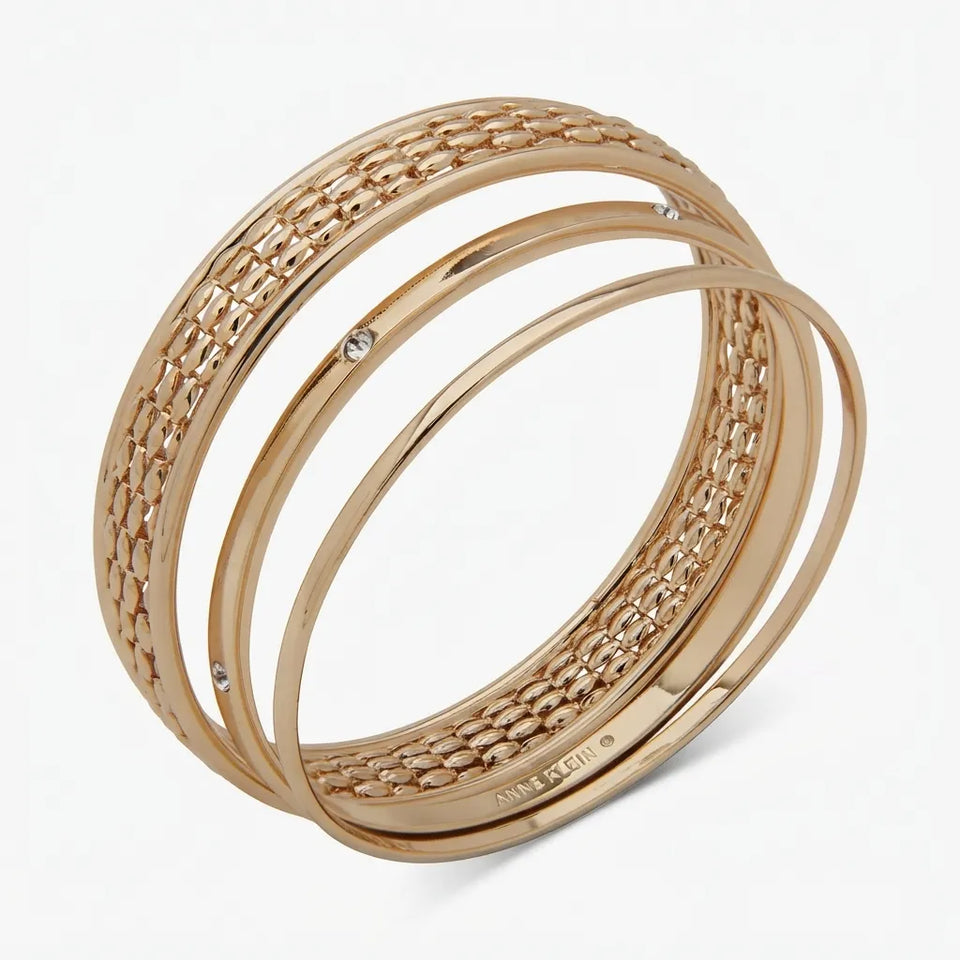 A set of three rose gold bangles with a woven textured pattern and small clear rhinestone accents, displayed on a clean white background.