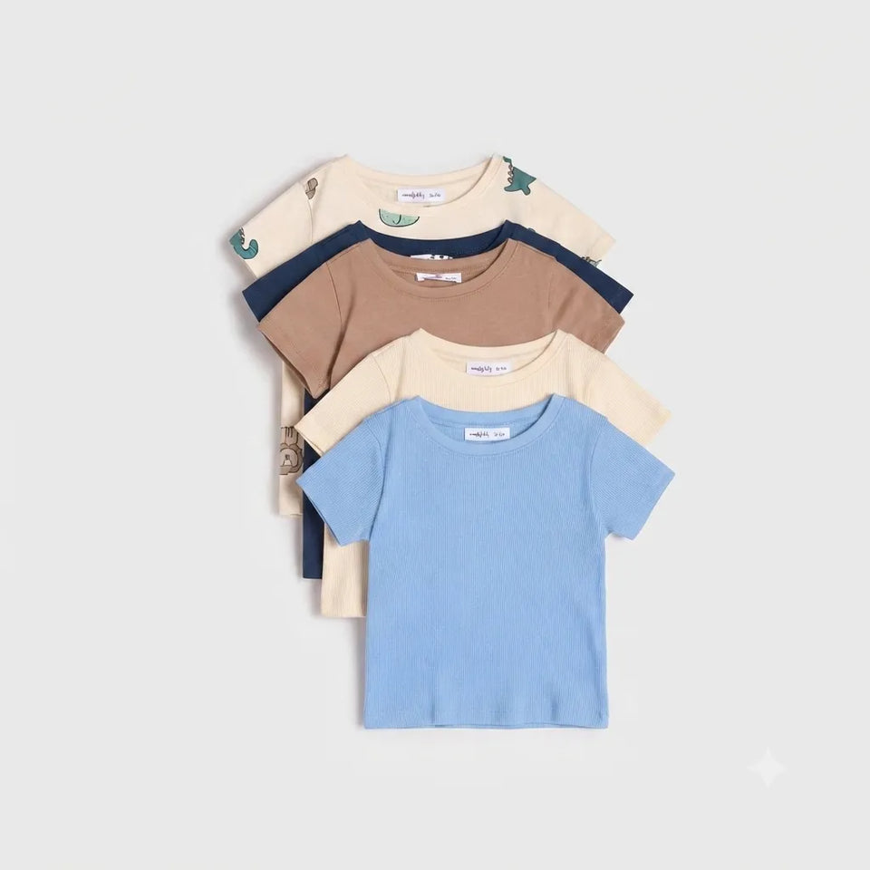 A stack of four children's short-sleeve t-shirts in different colors: light blue, beige, brown, and navy, with some shirts featuring small printed graphics, laid out on a light gray background.