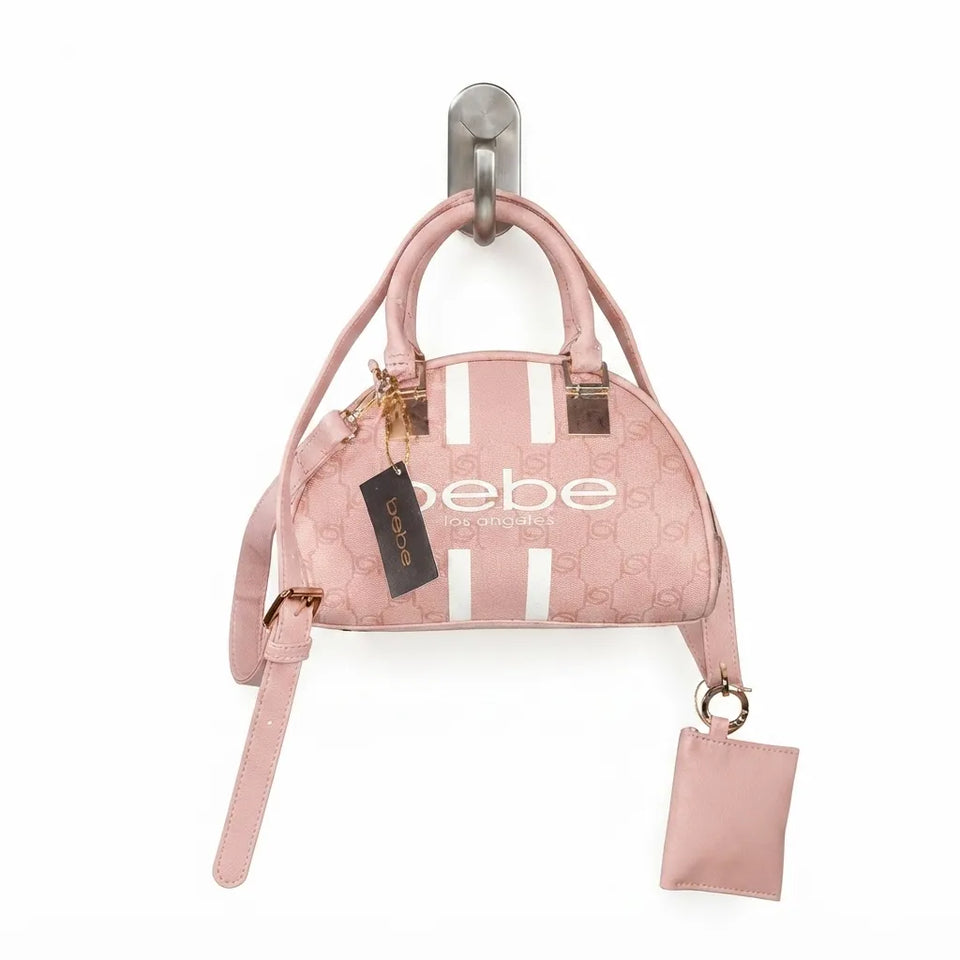 A pink Gucci dome-shaped handbag with white vertical stripes and the brand name 'bebe' printed on the front, hanging from a silver wall hook against a white background.