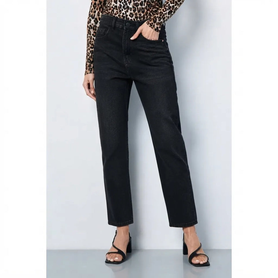 A model wearing black cropped straight-leg jeans, paired with a leopard-print long-sleeve top and black strappy heels, standing against a light gray studio background.