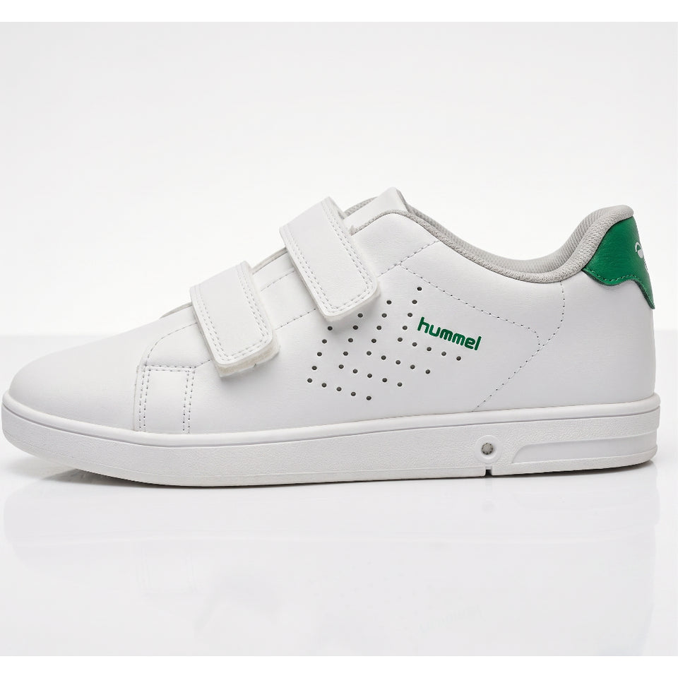 A white low-top children's sneaker by Hummel with two hook-and-loop straps, green logo text, and a green heel accent, shown in a side profile on a white background.