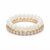 A stack of three stretch bracelets on a white background. The top bracelet is made of white pearls on a gold-tone band.