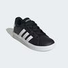 Black Adidas sneaker with white stripes on a light gray background