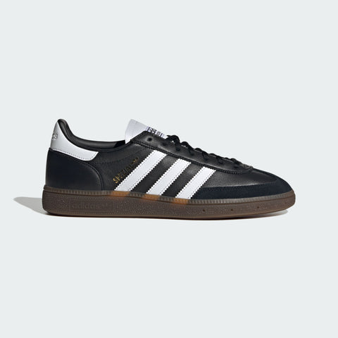 Black Adidas sneaker with white stripes on a light gray background